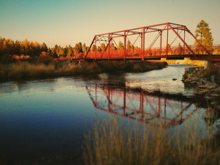Red steel Sheepherder’s Bridge over the Payette River at sunset